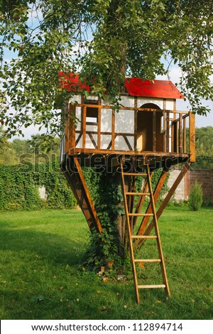 stock-photo-cute-small-tree-house-for-kids-on-backyard-german-style-112894714.jpg